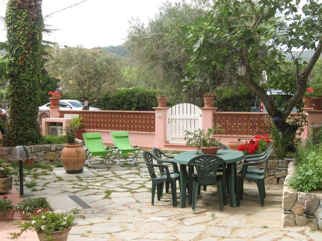 a patio with a table and chairs and a fence at Casale Pozzo al Moro in Marina di Campo