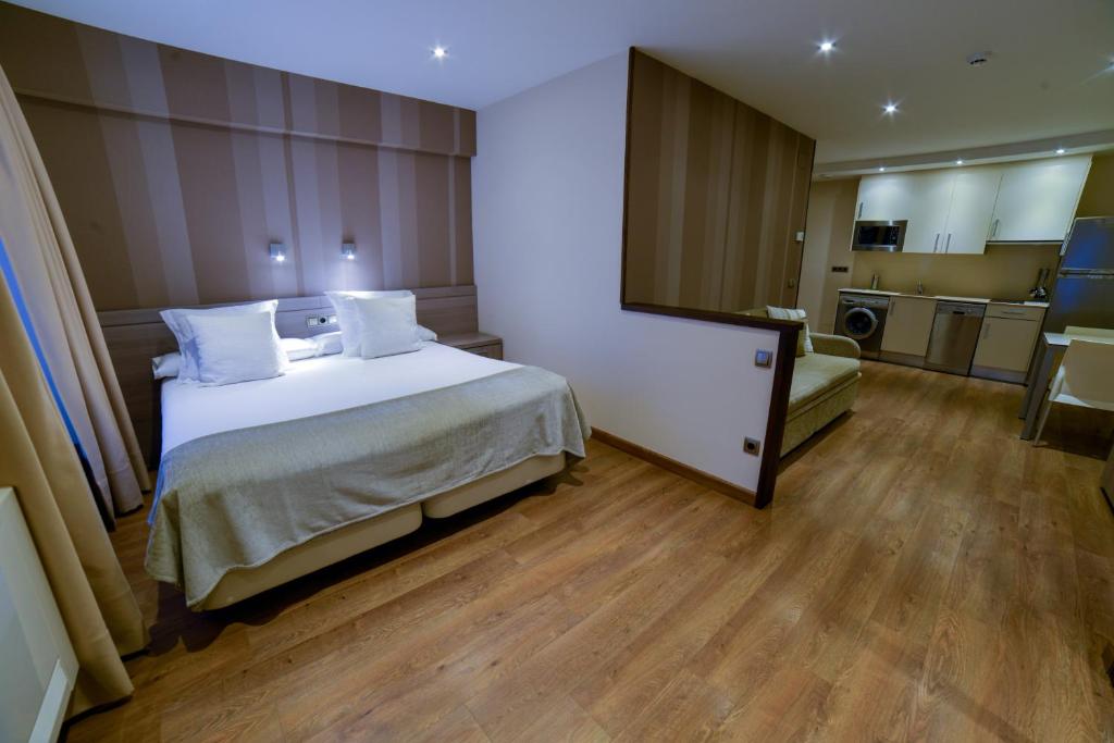 a hotel room with a bed and a kitchen at Apartamentos Turísticos Llanes in Llanes