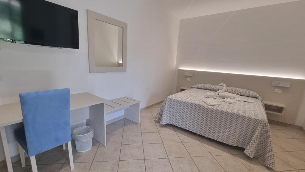 una camera da letto con scrivania, letto e tavolo di ValGiuSi Resort a Capo Vaticano