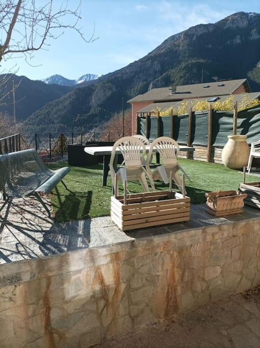 - deux chaises assises sur un mur en pierre dans l'établissement Joli 3 pièces au calme, à Saint-Martin-Vésubie