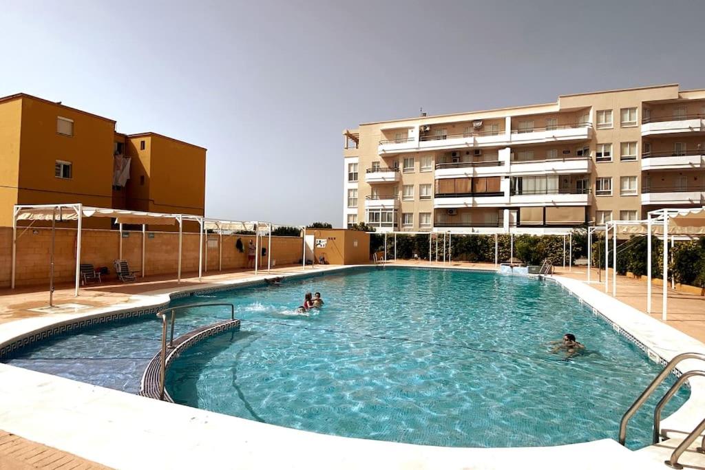 een zwembad in een gebouw met mensen erin bij Apartamento a unos pasos de la Playa (Rota) in Rota