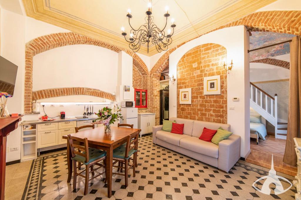 una cucina e un soggiorno con divano e tavolo di TO-Housing a Torino