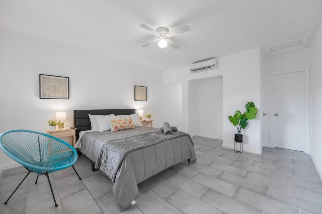 een slaapkamer met een bed en een blauwe stoel bij Fabulous Studio 15 min from The Beach in Miami