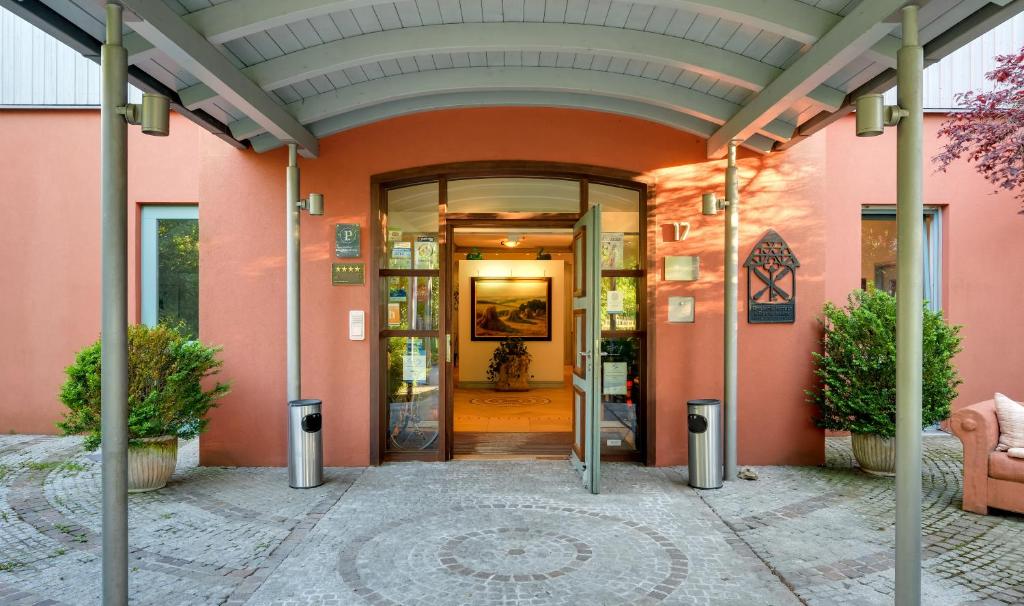 une entrée dans un bâtiment rose avec une porte en verre dans l'établissement Romantik Hotel Gasthaus Rottner, à Nuremberg