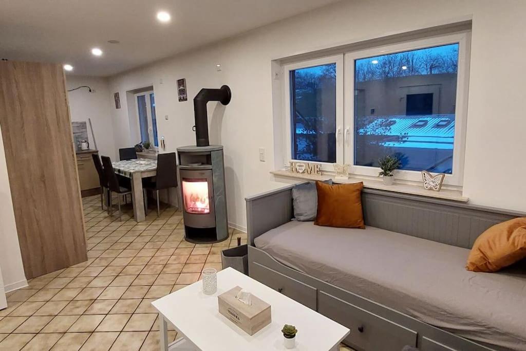 a living room with a couch and a stove in a room at Ferien-/Monteurwohnung im Odw. in Mörlenbach