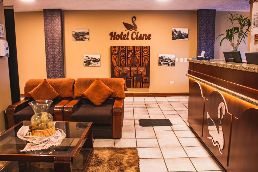 una sala de espera con sofá y mesa en Hotel Cisne en Cuenca