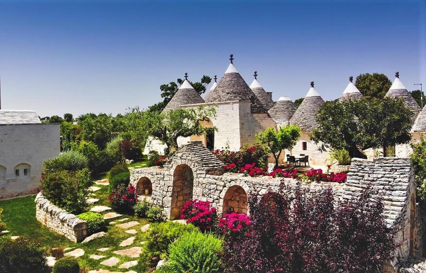 a large house with flowers in the yard at Trulli Arco Antico in Locorotondo