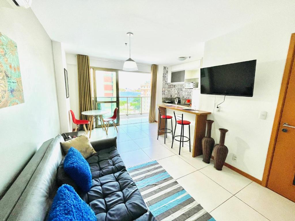 a living room with a couch and a kitchen at loft london, conforto no coração de Icarai in Niterói