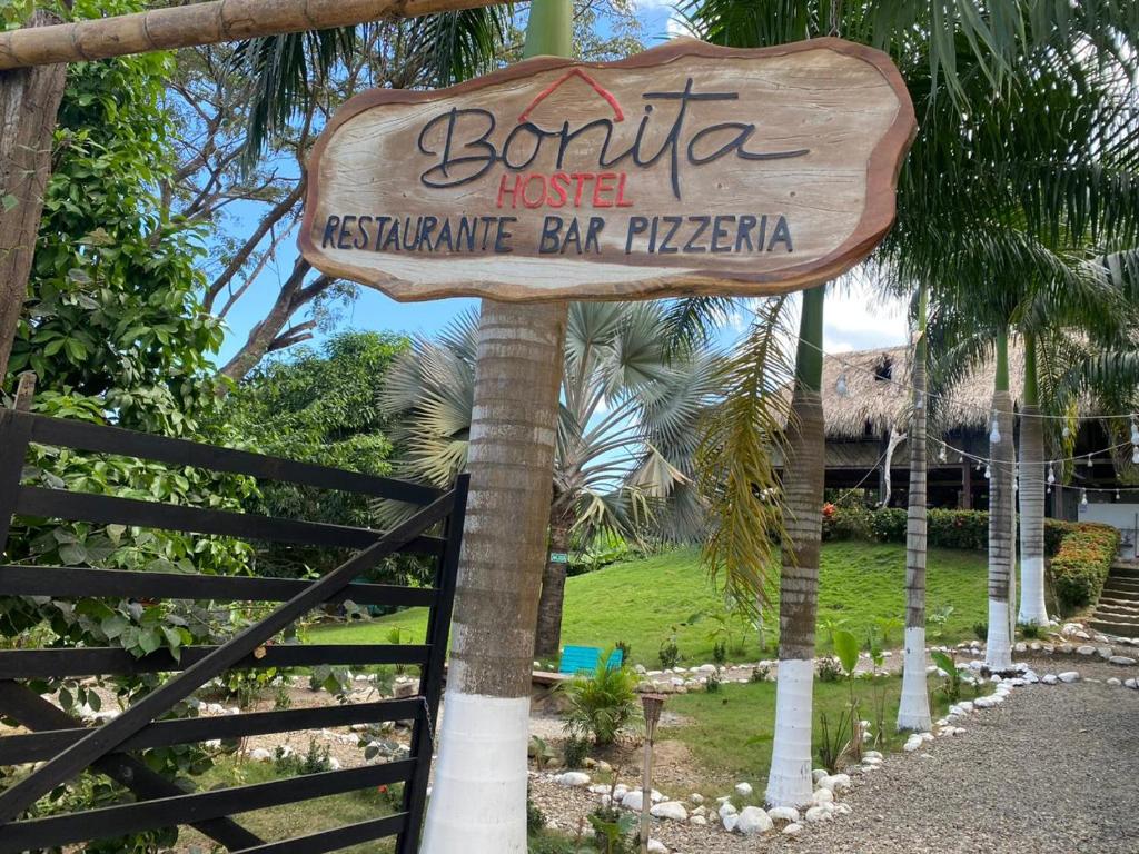 a sign for a hotel in front of a fence at BONITA HOSTEL in Palomino