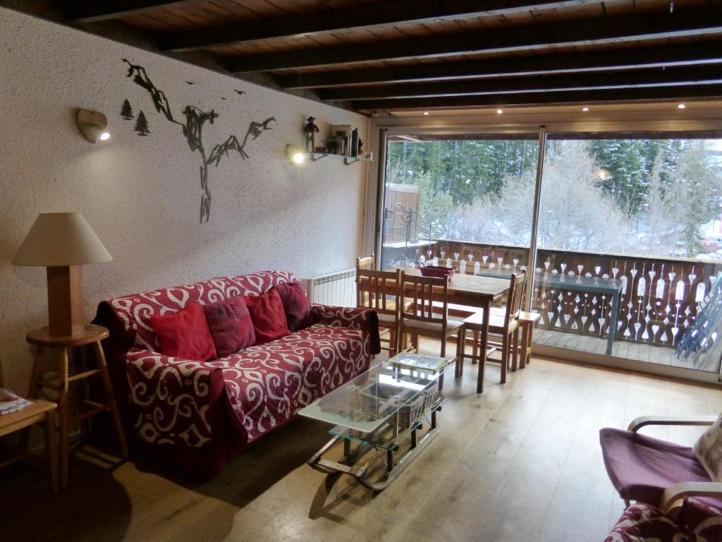 een woonkamer met een bank en een tafel bij Les Seolanes Pra Loup 520 in Pra-Loup