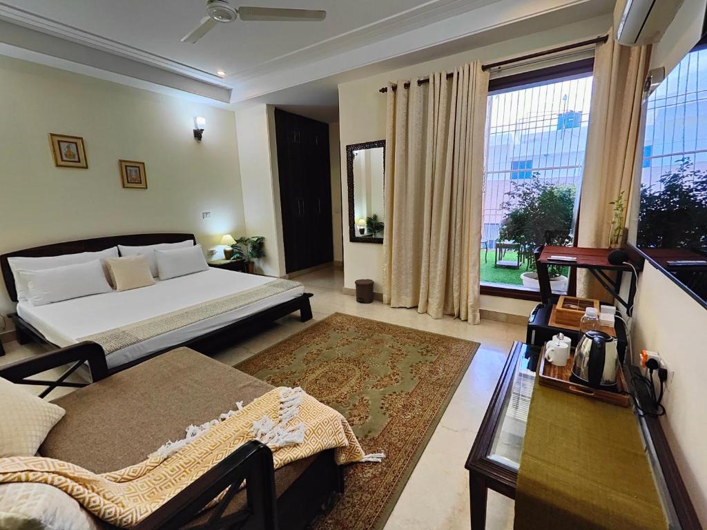 1 dormitorio con 2 camas y ventana grande en Niro GK2, en Nueva Delhi
