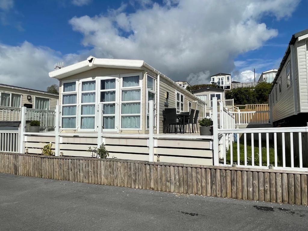 a white house with a wooden fence in front of it at Ladram Bay Holiday Park D54 in Otterton