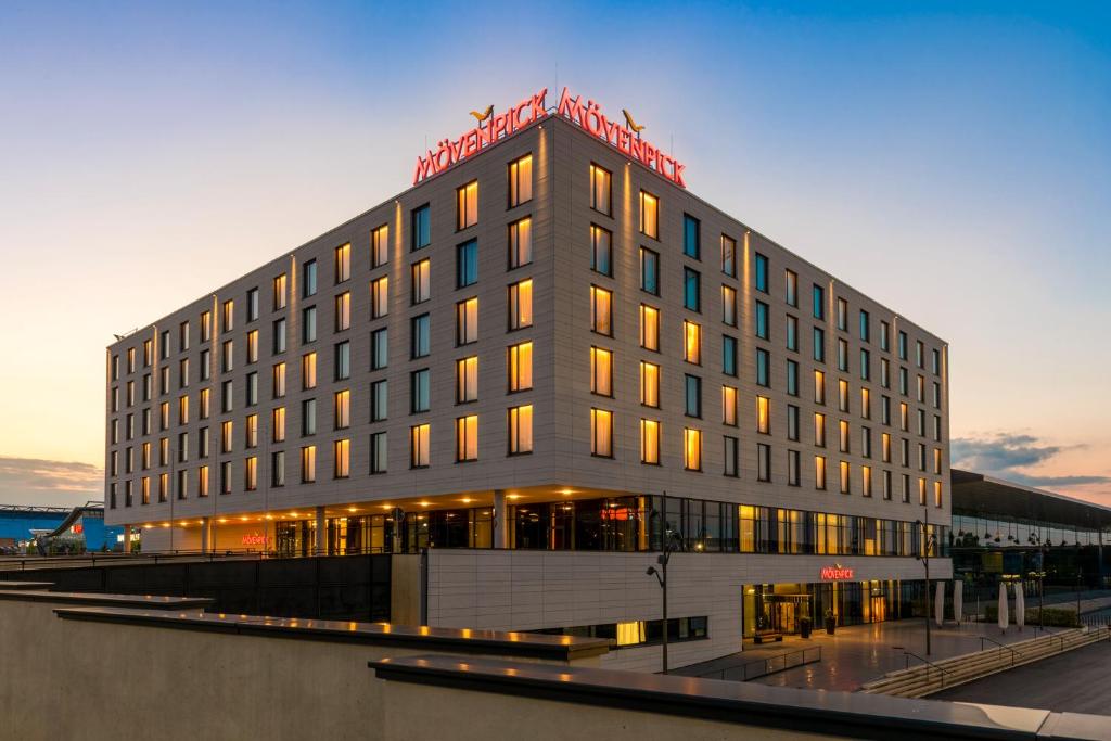 a large building with a sign on top of it at Mövenpick Hotel Stuttgart Messe & Congress in Stuttgart