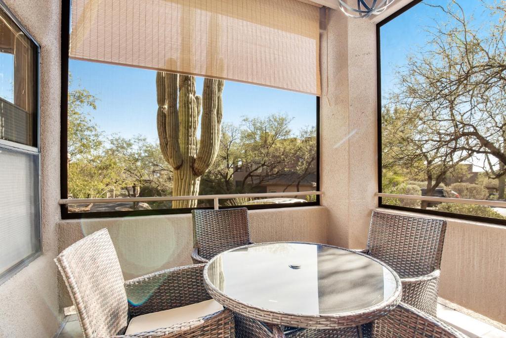 a balcony with a table and chairs and a cactus at Canyon Crest Condo in Tucson