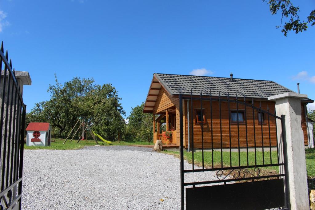 a house with a gate in front of a playground at Chalet du Lièvre in Hannappes