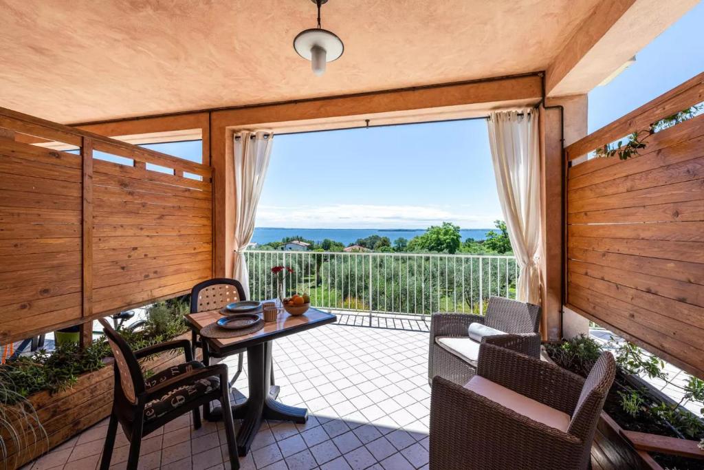 un porche cubierto con mesa y sillas en Residence Il Fiore Del Garda, en Manerba del Garda