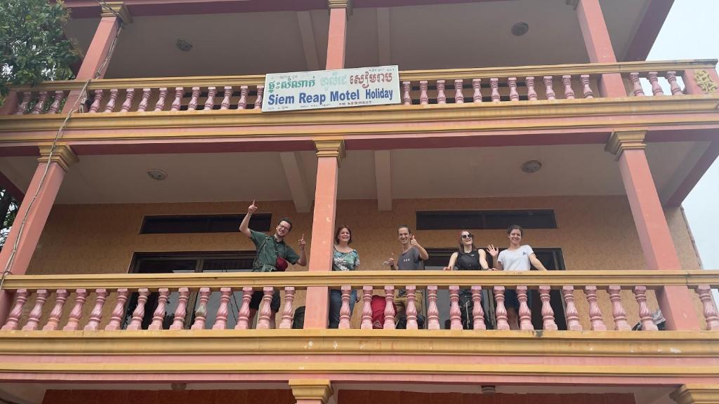 un grupo de mujeres de pie en el balcón de un edificio en Siem Reap Holiday Guest House or Motel, en Siem Reap