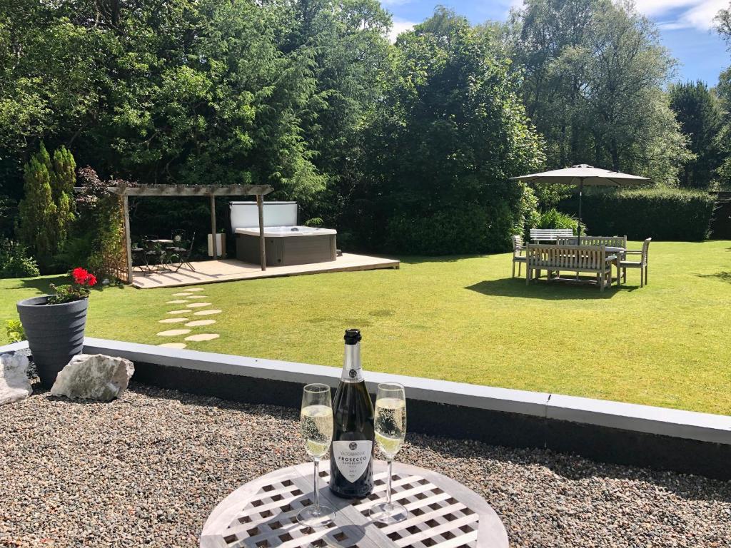 a bottle of wine sitting on a table in a garden at Distant Hills Guest House in Spean Bridge