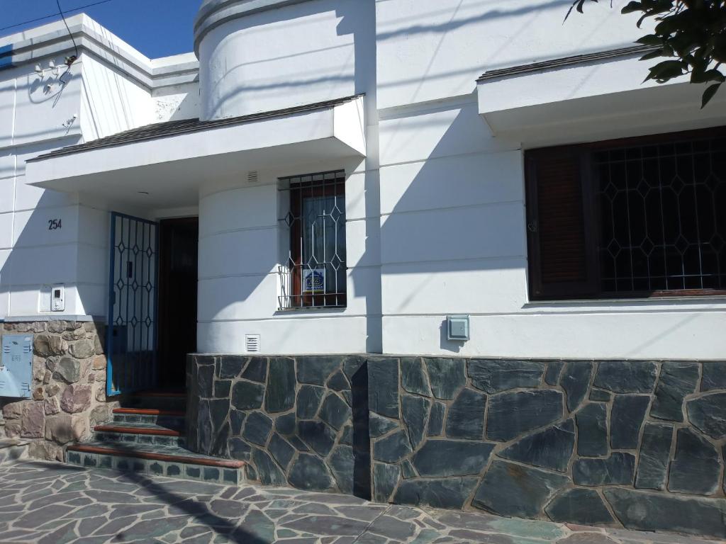 una casa bianca con un muro di pietra di Chalet del Rosedal a San Salvador de Jujuy