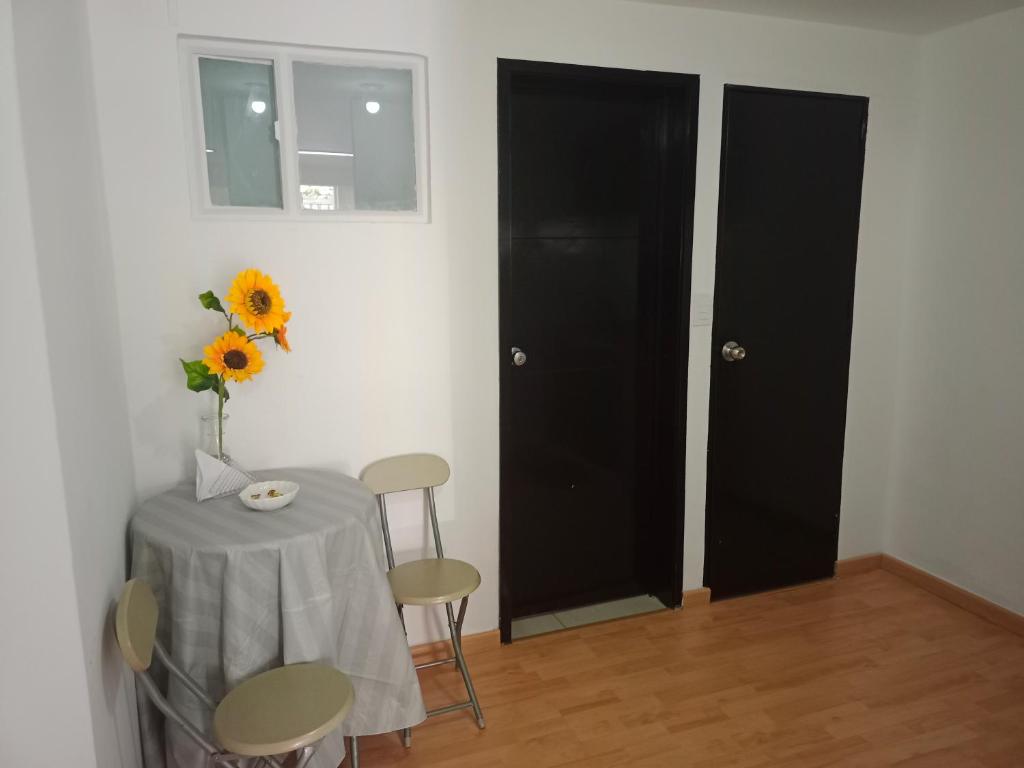 a table with a vase of sunflowers and a vase at V&B Apartamento in Bogotá