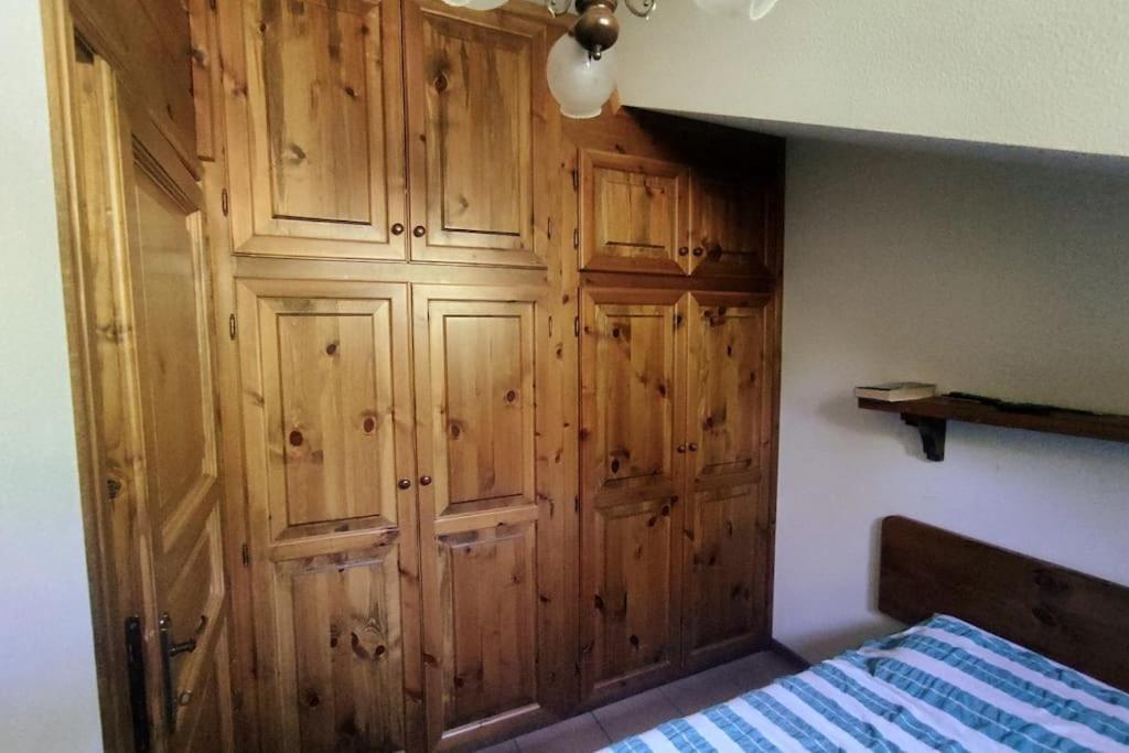 Schlafzimmer mit Holzschränken und einem Bett in der Unterkunft Chalet Elegante - Campo Felice e Piste da scii in Spogna