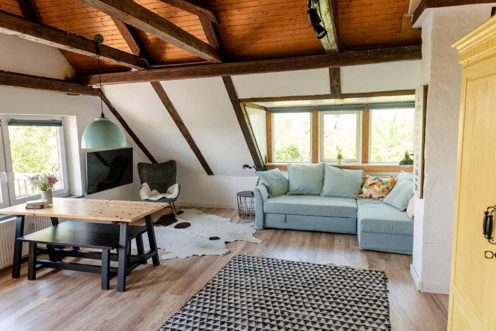 a living room with a blue couch and a table at Loft auf Fehmarn 800m zum Strand in Fehmarn