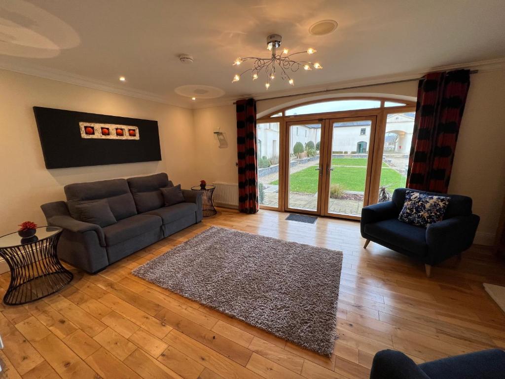 ein Wohnzimmer mit einem Sofa und einem Stuhl in der Unterkunft 24 Castle Hume Court Holiday House in Enniskillen