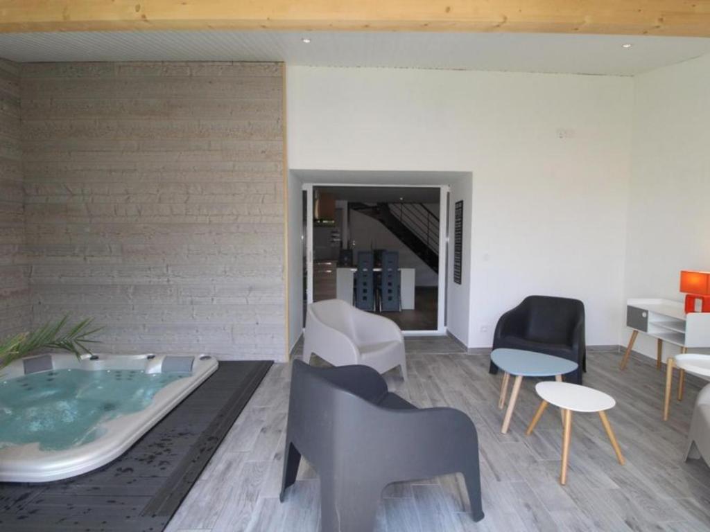 a living room with a jacuzzi tub and chairs at Gîte de Laphine avec Spa Privé in Savas