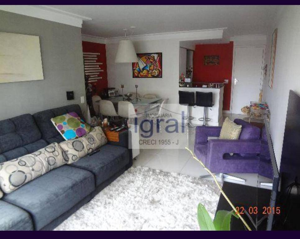 uma sala de estar com um sofá azul e uma cozinha em Quarto só seu! em São Paulo