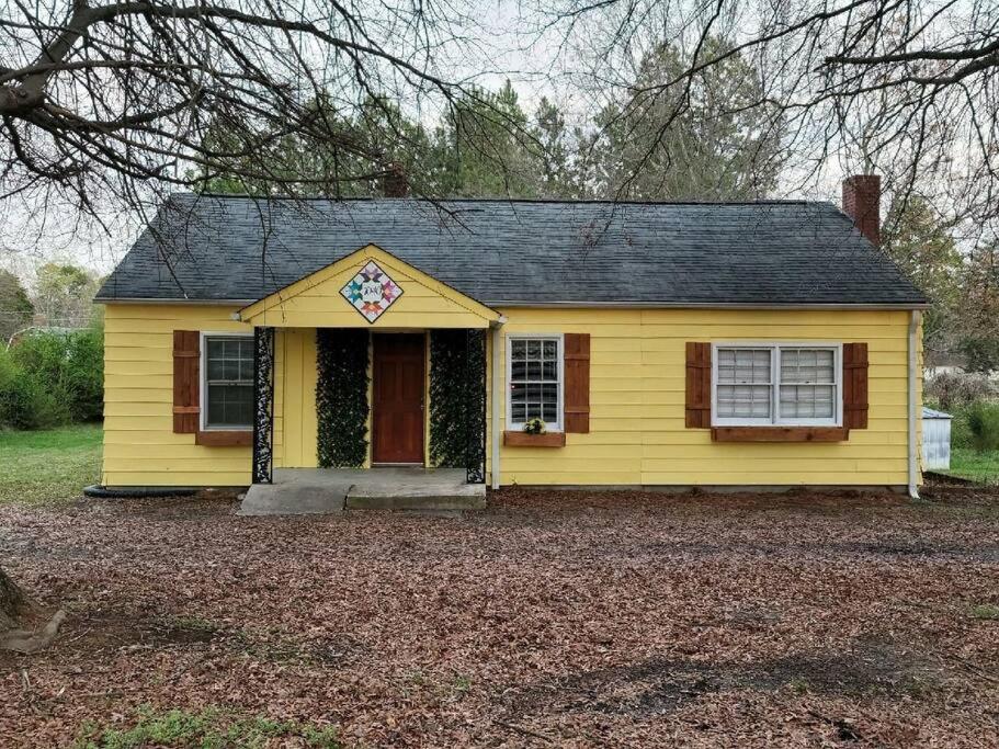 a yellow house with a cross on top of it at Cozy bungalow near Hanging Rock and Chateau Vie. 
