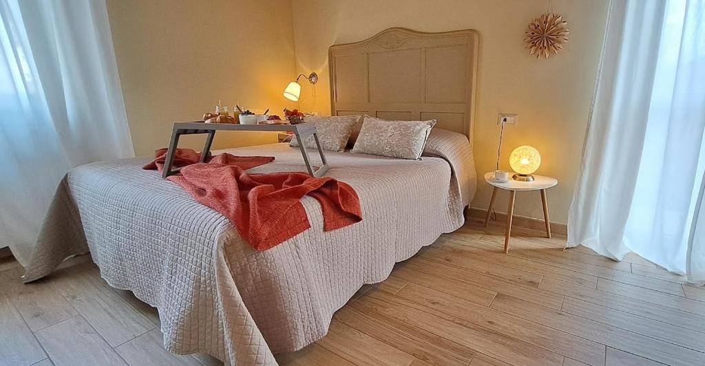 B&B Tra i Laghi في Casale Corte Cerro: غرفة نوم مع سرير مع بطانية حمراء عليه