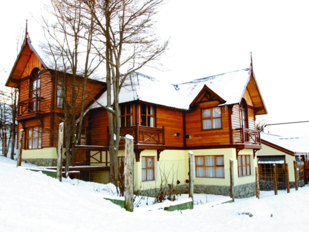 a large wooden house in the snow at Cabañas Las Aguilas ADHERIDA PREVIAJE in Ushuaia