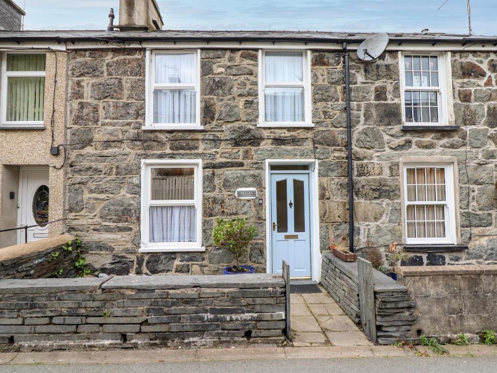 an old stone house with a blue door at Trigfa in Blaenau-Ffestiniog