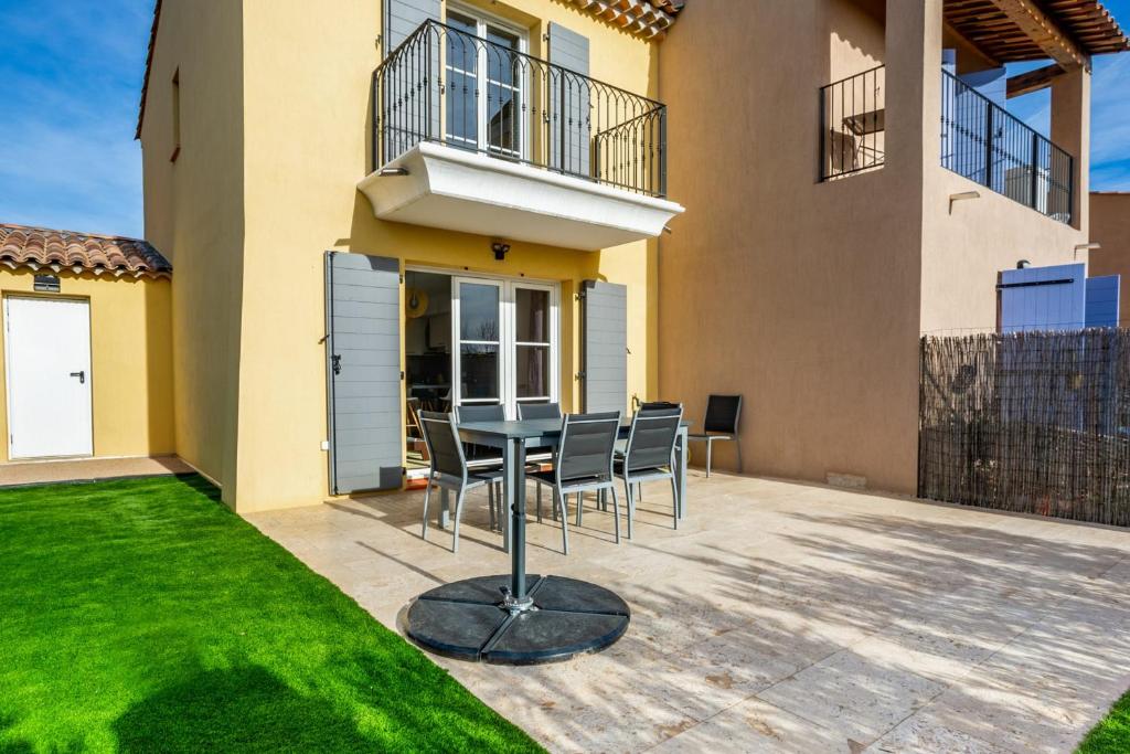 a patio with a table and chairs in front of a house at Nice house with terrace 5 min to Port Grimaud - Welkeys in Grimaud