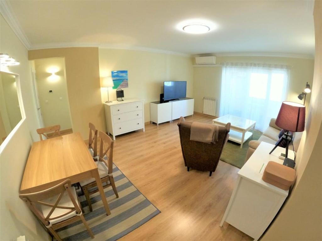 un soggiorno con un tavolo e una sala da pranzo di Carnaxide modern T1 apartment w balcony in Carnaxide Oeiras Lisbon a Carnaxide