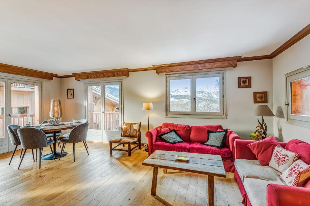 a living room with a red couch and a table at Superb and calm flat with balcony in Megève - Welkeys in Megève