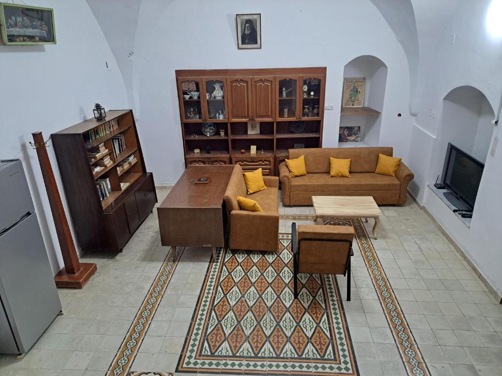 a living room with a couch and a tv at The Lemon Homes in Bayt Sāḩūr