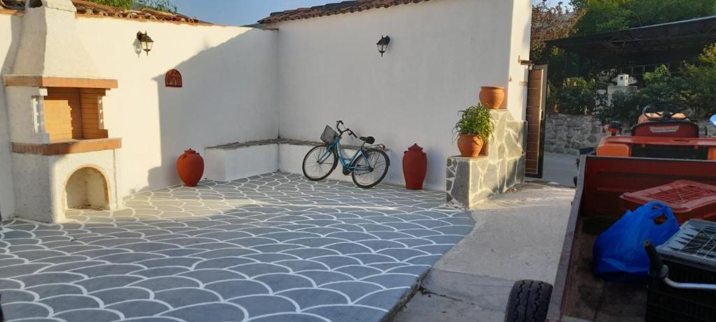 a bike parked next to a white building with a courtyard at Sunny Room in Áyios Yeóryios
