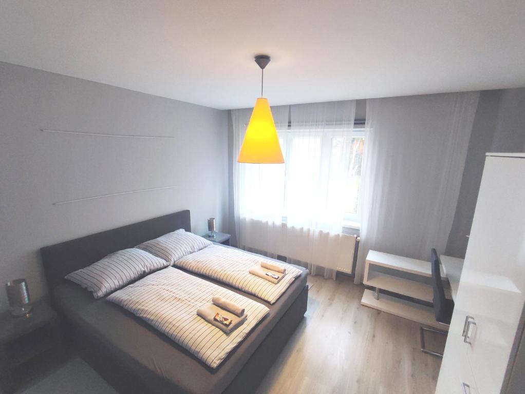 um quarto com uma cama e uma luz amarela em Alisa Apartments em Kostomlaty