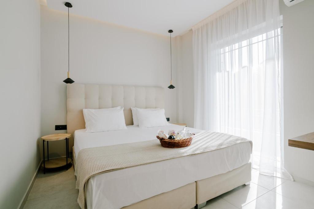 a bedroom with a white bed with a basket on it at Aelia Prime Experience 3 in Kos Town