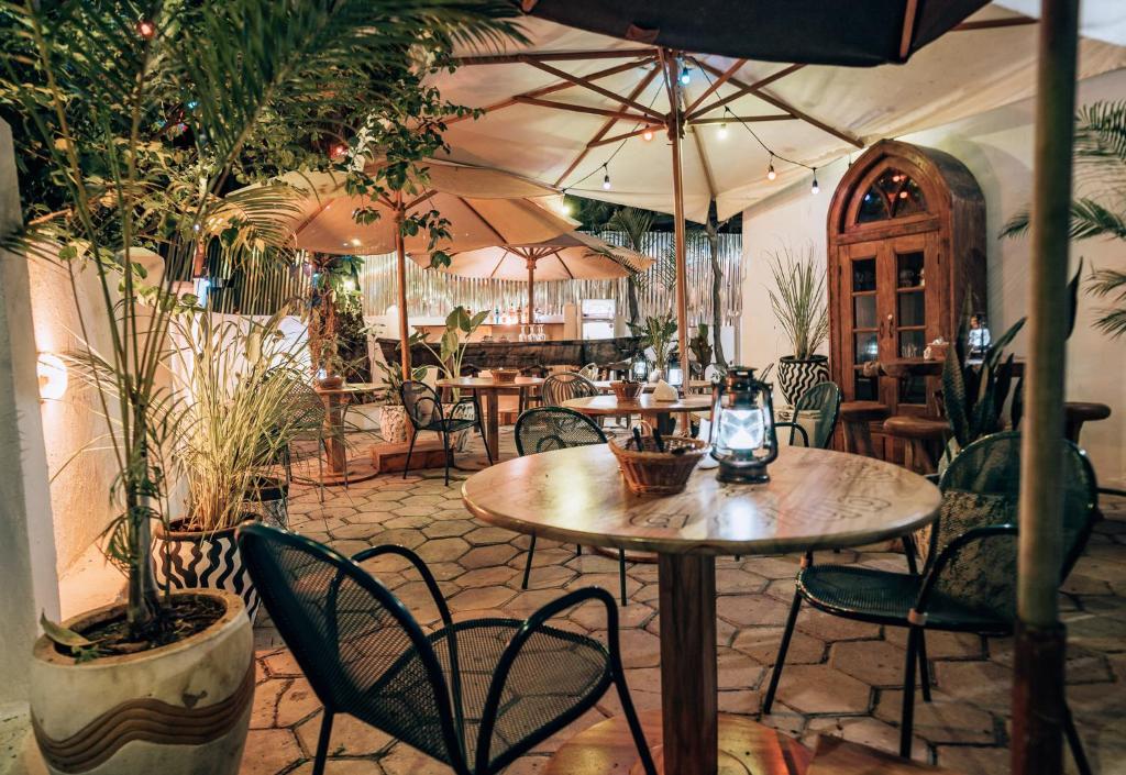 a restaurant with tables and chairs and umbrellas at Kahawa house in Zanzibar City