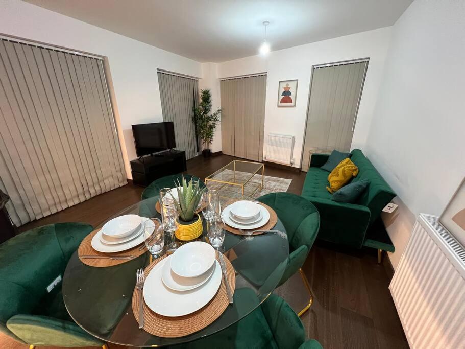 een woonkamer met een tafel en groene stoelen bij Dartford Lux Stay one bedroom apartment in Dartford