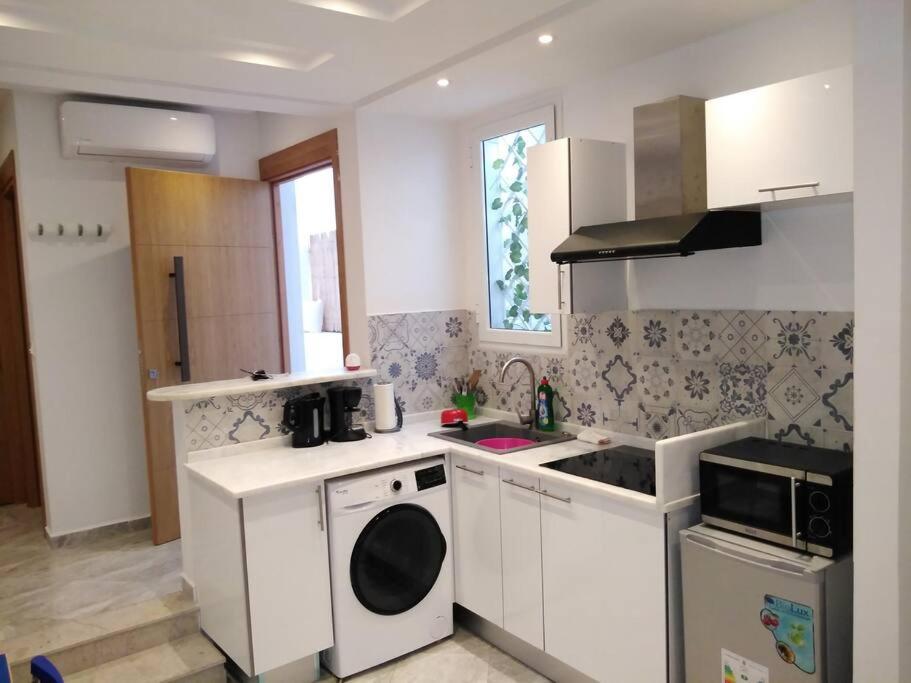 a kitchen with a sink and a stove top oven at *APPARTEMENT NEUF AVEC TERRASSE À LA MARSA*** in La Marsa