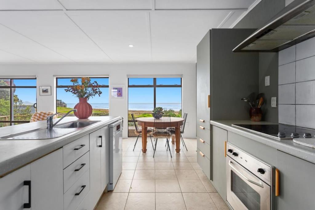 a kitchen with white counters and a table at Beach, Bikes and Bonfires in Opotiki