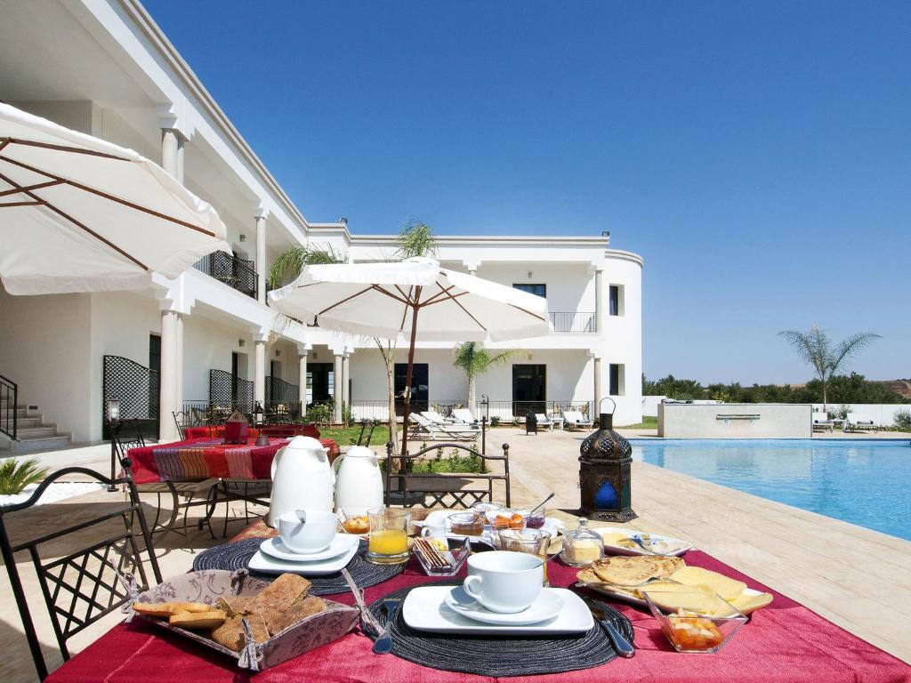 a table with food and drinks on it next to a pool at Villa Agapanthe in Fez