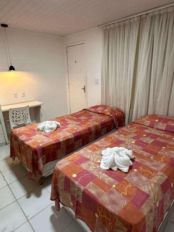 two beds in a hotel room with towels on them at Hotel Pousada Villa Marina in Fortaleza