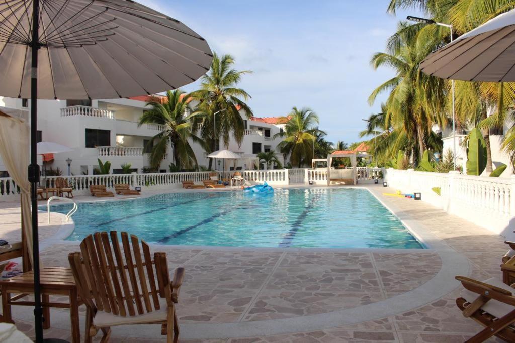 a swimming pool with two chairs and an umbrella at VAIA HOTELES in Coveñas