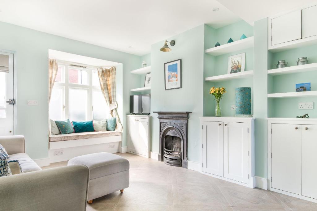 a living room with blue walls and a fireplace at Eden Cottage in Whitstable