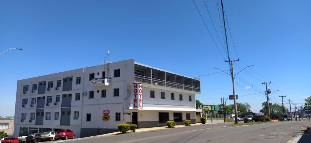 a white building on the corner of a street at Hotel Rota 282 in São Miguel dʼOeste