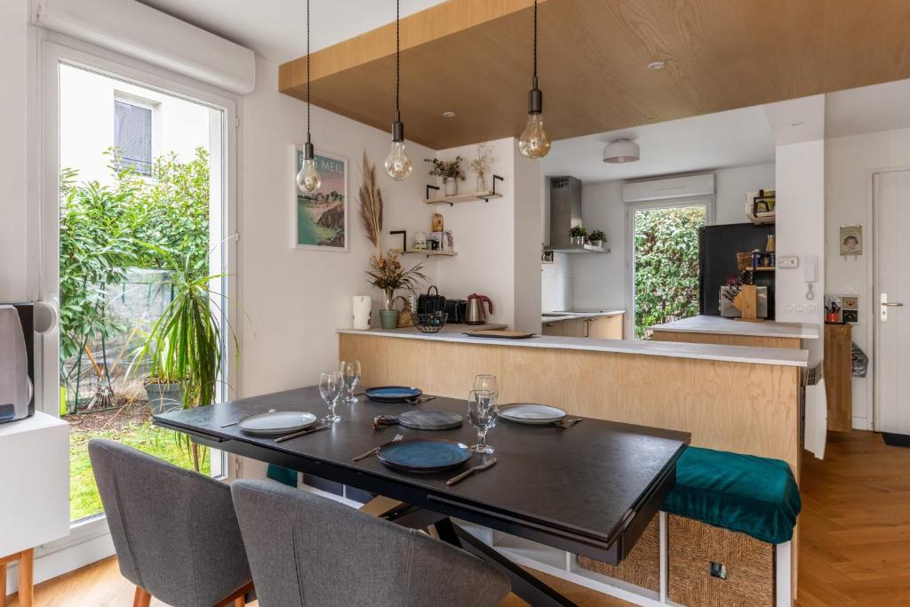 uma sala de jantar e cozinha com mesa e cadeiras em City house with garden near Part-Dieu in Lyon - Welkeys em Lyon